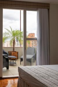 - une chambre avec un lit et une vue sur un balcon dans l'établissement Monreale Express Ribeirão Preto, à Ribeirão Preto