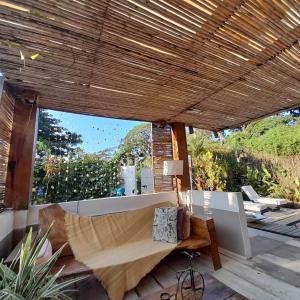 eine Terrasse mit einem Sofa, einem Tisch und einem Fenster in der Unterkunft Casa Kai in Palomino