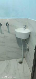 La salle de bains est pourvue d'un lavabo blanc mural. dans l'établissement OYO Hotel Sky Bird, à Pehowa