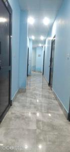 un couloir avec des murs bleus et un long couloir avec des portes dans l'établissement OYO Hotel Sky Bird, à Pehowa