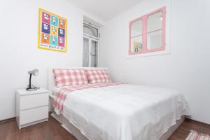 a white bedroom with a bed and a window at Apartment Zdenac in Rovinj