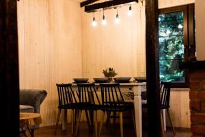 a dining room with a table with four chairs at Sosnowy Strumyk in Łaziska