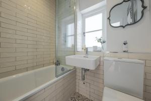 a white bathroom with a sink and a bath tub at Holkham Skies 2 in Wells next the Sea +34 photos