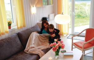 two girls sitting on a couch reading a magazine at Friedrichskoog-Deichblick 22 in Friedrichskoog