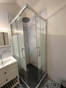 una doccia con una porta in vetro accanto a un lavandino di Charmante petite maison a Bourges