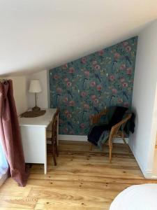 Habitación con escritorio, mesa y pared. en Charmante petite maison, en Bourges