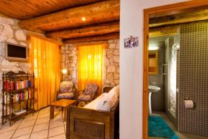 a living room with a tv and a bathroom at Liuba Villas in Vasilikos