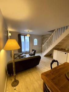 soggiorno con divano, tavolo e scale di Charmante petite maison a Bourges 1 altra foto