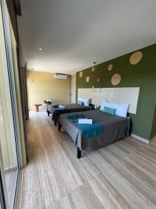 3 camas en una habitación con paredes verdes en LOL-HA Hotel Boutique, en Cancún