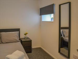 a bedroom with a bed and a mirror at Ellas Apartment in Skegness