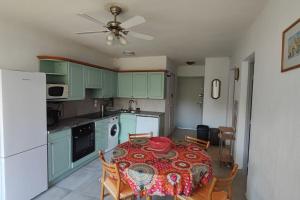 une cuisine avec une table avec une assiette rouge dessus dans l'établissement Calvi T3 climatisé 150 m plage, à Calvi 7 autres photos