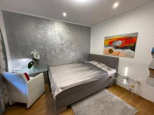 a bedroom with a bed and a painting on the wall at Airport Rooms Waldblick in Cologne