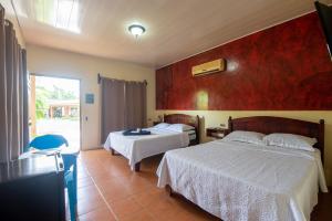 a hotel room with two beds and a window at Hotel & Hot Springs Sueño Dorado in Fortuna