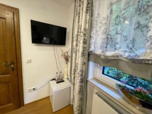 Habitación con ventana, TV y cortina. en Airport Rooms Waldblick, en Colonia