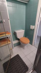 La salle de bains est pourvue de toilettes et d'un siège en bois. dans l'établissement Calvi T3 climatisé 150 m plage, à Calvi