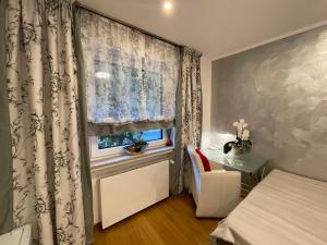 a bedroom with a bed and a window with curtains at Airport Rooms Waldblick in Cologne