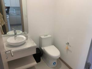 a bathroom with a white toilet and a sink at Newly built Apartment in Quito (Carolina-Iñaquito) in Quito