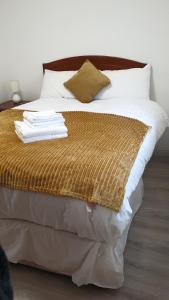 Ein Bett mit einem Haufen Handtücher drauf. in der Unterkunft Lower Main Street Apartment in Letterkenny