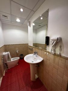 96 Hostel Dubai في دبي: حمام مع حوض ومرحاض ومرآة