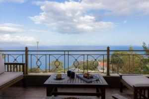 a balcony with a table and a view of the ocean at Three Elements in Pefkali