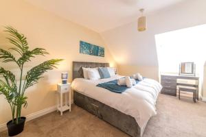 a bedroom with a large bed and a plant at Luxury 3 Bed house, sleeps 8 people, with parking! in Bristol