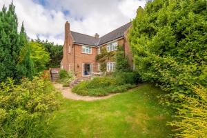 an exterior view of a brick house with a yard at Low Wood in West Runton