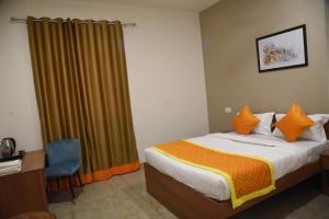 um quarto de hotel com uma cama, uma secretária e uma janela em Southern Grand Kashi - Inside Kashi Vishwanath Temple Corridor em Varanasi
