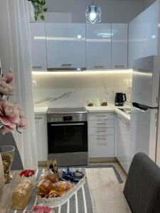 a kitchen with white cabinets and a table with food at Helen's Little Castle free private parking in Thessaloniki