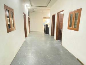 a hallway of a room with white walls and concrete floors at OYO Hotel Mahima in Pānīpat