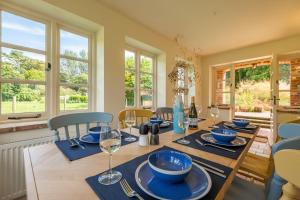 uma sala de jantar com uma mesa com pratos azuis em Loke Cottage em Thurgarton