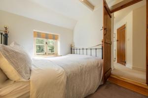 um quarto branco com uma cama e uma janela em Loke Cottage em Thurgarton