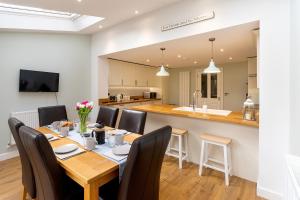 a dining room with a table and chairs and a kitchen at Burbage View in Buxton