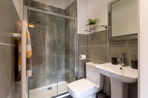 a bathroom with a shower and a toilet and a sink at Burbage View in Buxton +20 photos