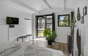 Schlafzimmer mit einem Bett und einem Flachbild-TV in der Unterkunft 4 Bedroom Stunning Home In Bogense in Bogense