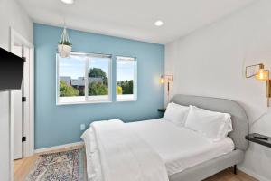 a blue bedroom with a bed and a window at Isla's sweet suite - Micro Studio - 91Walkscore in Seattle