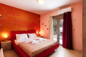 1 dormitorio con 1 cama con pared roja en Anna Maria, en Kalamitsi Amygdali
