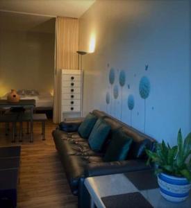 a living room with a leather couch and a bedroom at Talponia 212 in Ivrea