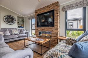 a living room with two couches and a fireplace at Twelve Burnham Lodge in Burnham Market