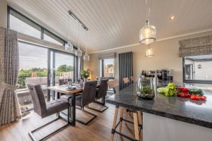 a kitchen and dining room with a table and chairs at Twelve Burnham Lodge in Burnham Market