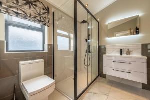 a bathroom with a shower and a toilet and a sink at Twelve Burnham Lodge in Burnham Market +31 photos