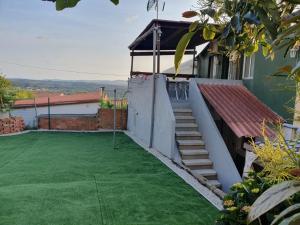 un patio trasero con césped verde y escaleras a una casa en Apartamento Marypaz, en Valdoviño