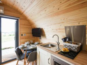 a kitchen in a tiny house with a sink and a table at Celyn Bach - Uk37083 in Llanwddyn