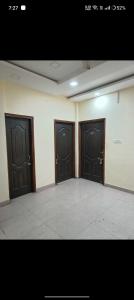 two black doors in a room with a tile floor at OYO The Rich Chair Hotel Restaurant And Banquet Hall in Kaliānpur