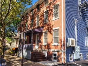 una casa de ladrillo con una puerta abierta en una calle en Beautiful Wooster Sq. getaway - great neighborhood en New Haven