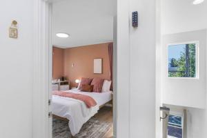 een slaapkamer met een bed met witte lakens en roze kussens bij Elvis's Sweet Suite - 84 Walkscore in Seattle