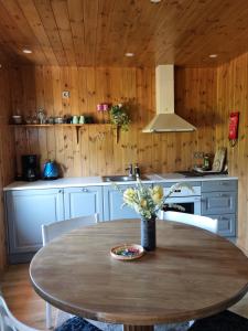 a kitchen with a table with a vase of flowers on it at Sunset puhkemaja in Kaigutsi +8 photos