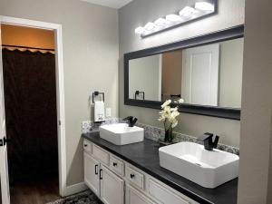 uma casa de banho com 2 lavatórios e um espelho grande em New Remodeled Luxury Condo By The Lake, No Stairs! em Branson