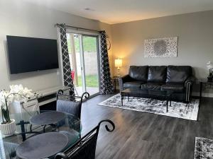 a living room with a black leather couch and a table at New Remodeled Luxury Condo By The Lake, No Stairs! in Branson