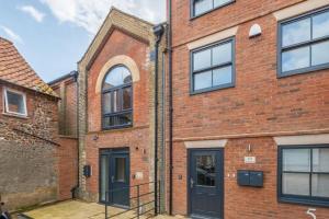 a brick building with black doors and windows at 7 Swan Court in Fakenham