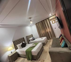 a hotel room with two beds and a couch at Ferme Prestige in Moulay Yacoub